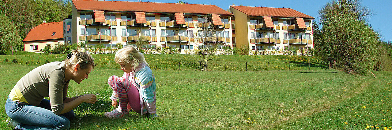 1920_Bettenhaus_Frühling_Mutter_mit_Kind.jpg Blick auf das Bettenhaus im Sommer Mutter mit Kind im Vordergrund
