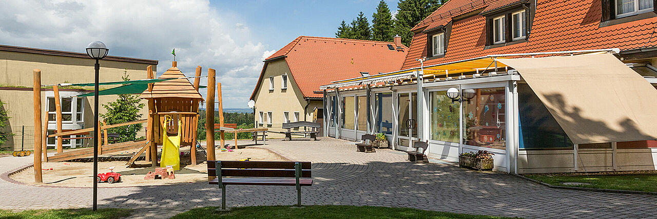 1920_Kinderhaus_Sommer.jpg Blick auf Spielplatz und Kinderhaus der Kureinrichtung Haus am Jonsberg