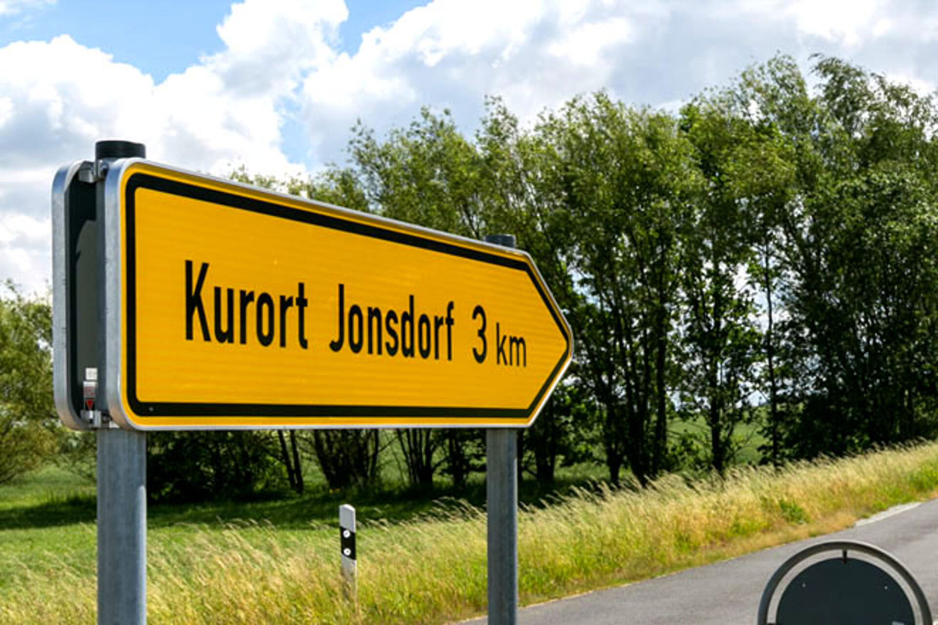 Wegweiser Kurort Jonsdorf am Straßenrand, aus Auto heraus fotografiert