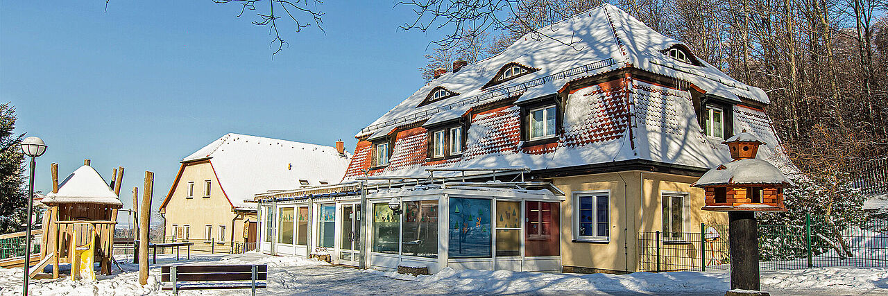 Kinderhaus und verschneites Außengelände der Kureinrichtung Haus am Jonberg