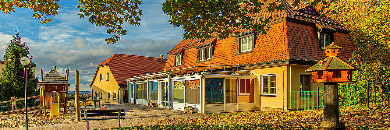 1920_Herbst-Kinderhaus.jpg Blick auf Spielplatz und Kinderhaus der Kureinrichtung Haus am Jonsberg im Herbst