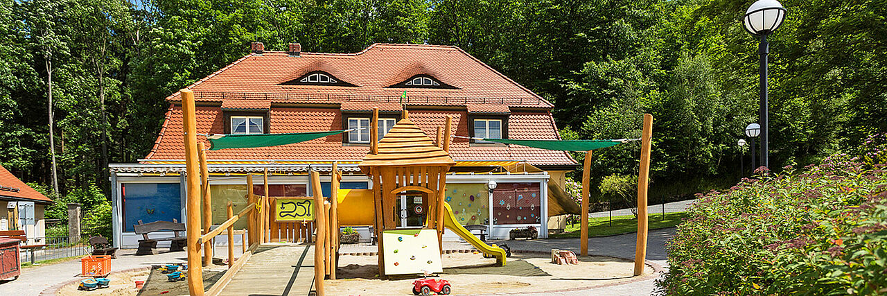 1920_Kinderhaus_Sommer1.jpg Blick auf Spielplatz und Kinderhaus der Kureinrichtung Haus am Jonsberg