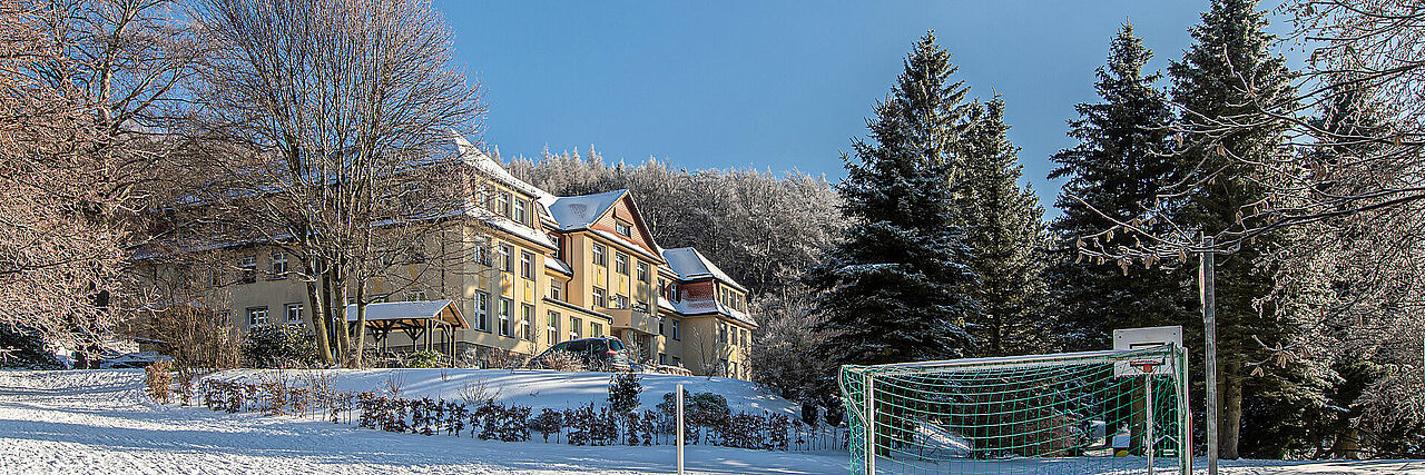 Blick vom Bolzplatz auf das Haupthaus im Winter